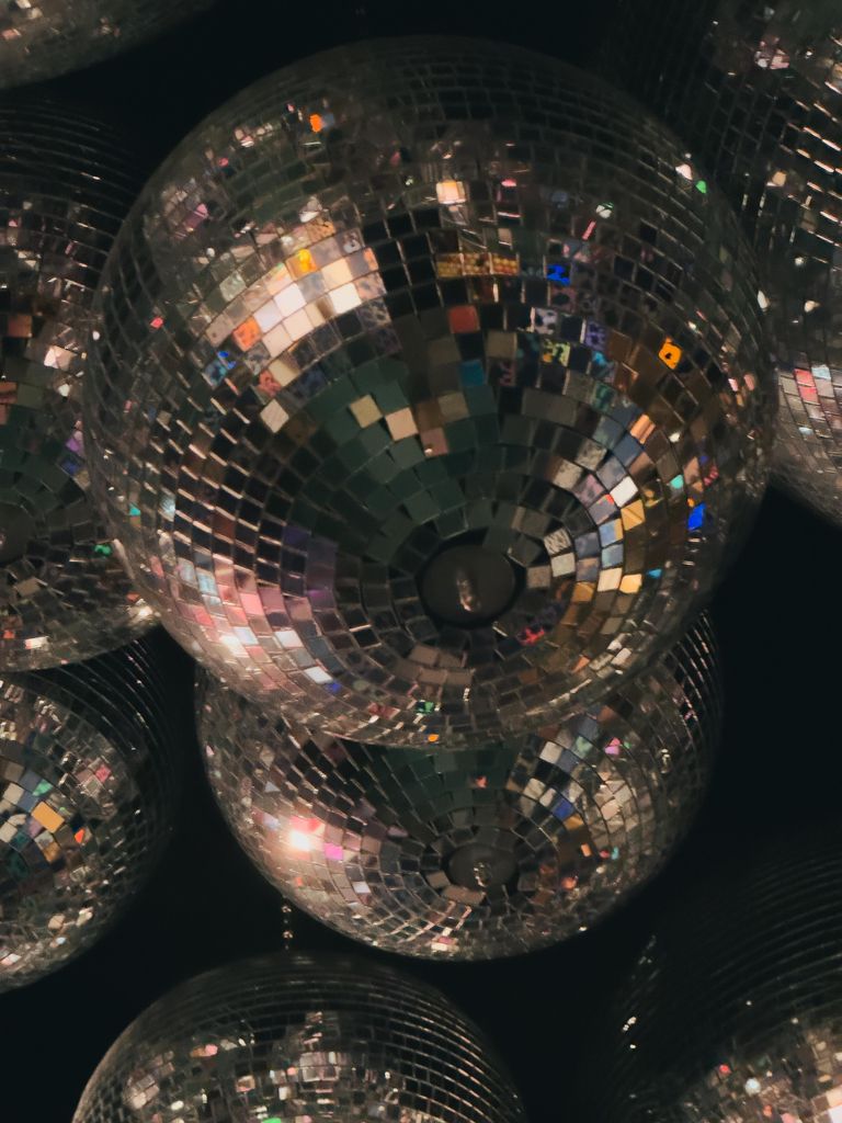 Multiple disco balls hanging in a vibrant nightclub setting in Amsterdam, capturing the nightlife energy.