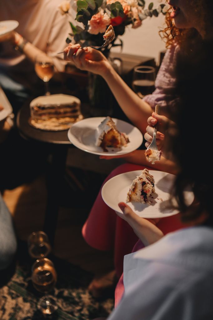 Warm indoor birthday celebration with friends enjoying cake and conversation.