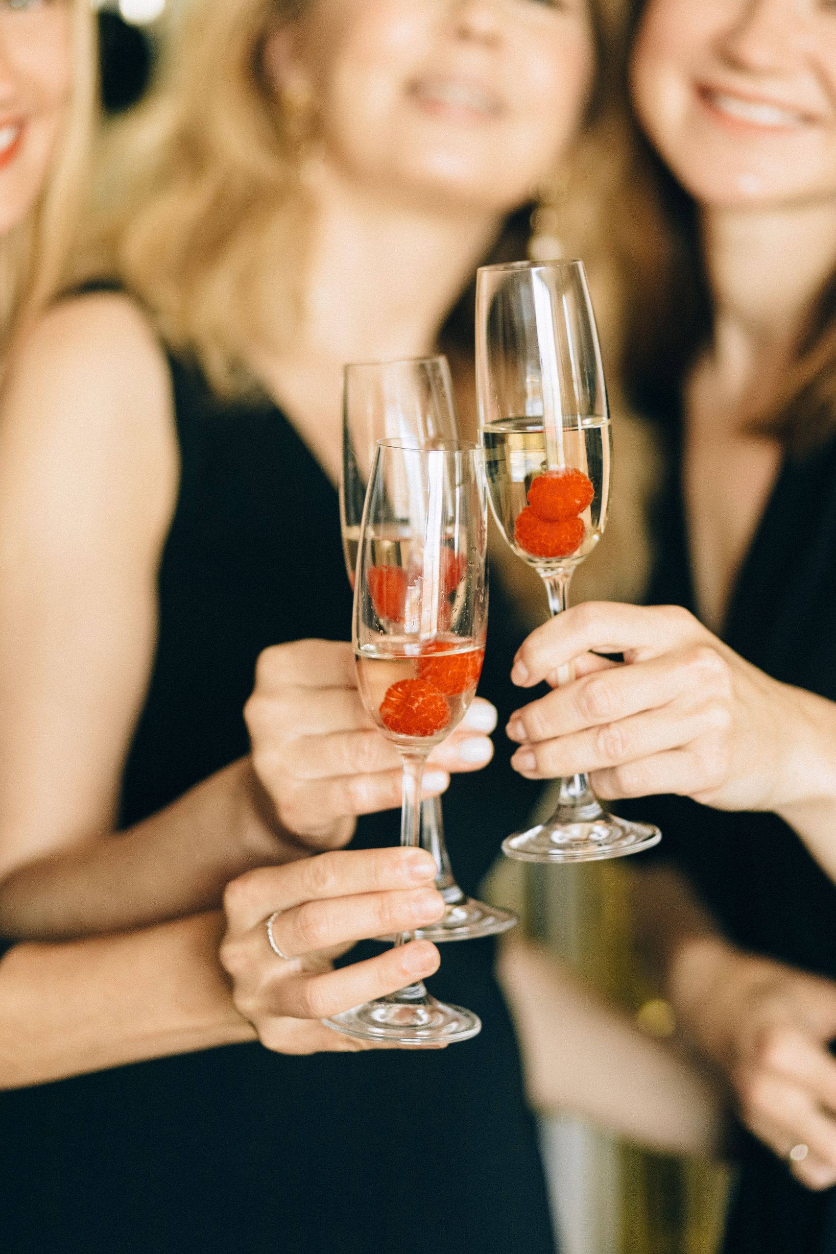 A group of women celebrating with champagne and raspberries at a party.